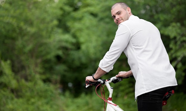 Porträt des eleganten Mannes, der glücklich ist, Fahrrad zu fahren