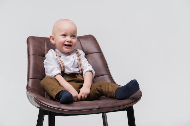 Porträt des entzückenden babys sitzend auf einem stuhl