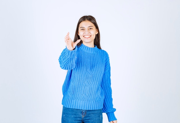 Porträt des entzückenden Mädchens in der blauen Strickjacke auf Weiß.