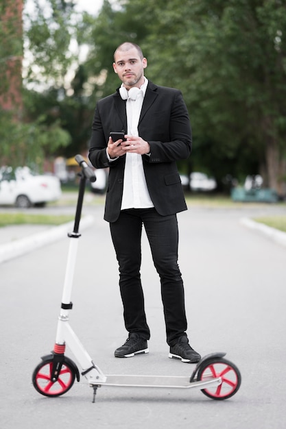 Kostenloses Foto porträt des erwachsenen mannes bereit, roller zu fahren