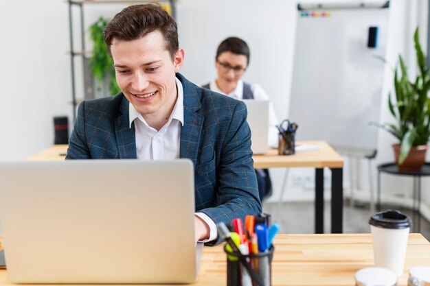 Porträt des erwachsenen Mannes, der am Laptop arbeitet