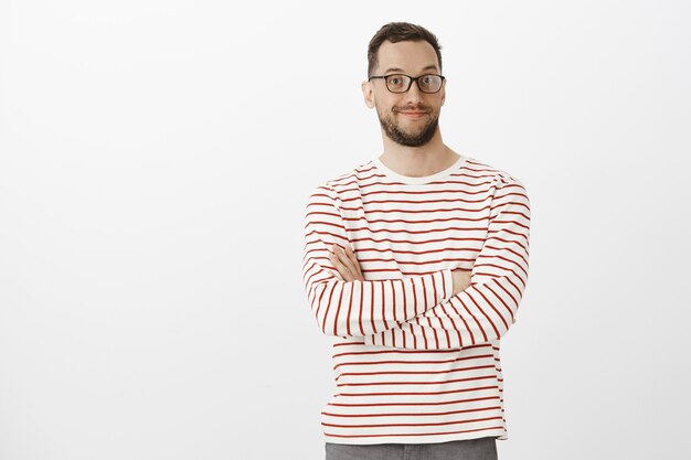 Porträt des faszinierten angenehmen gutaussehenden Mannes in der schwarzen Brille, breit lächelnd