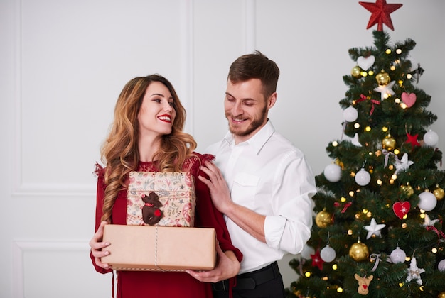 Porträt des fröhlichen Paares mit Weihnachtsgeschenk