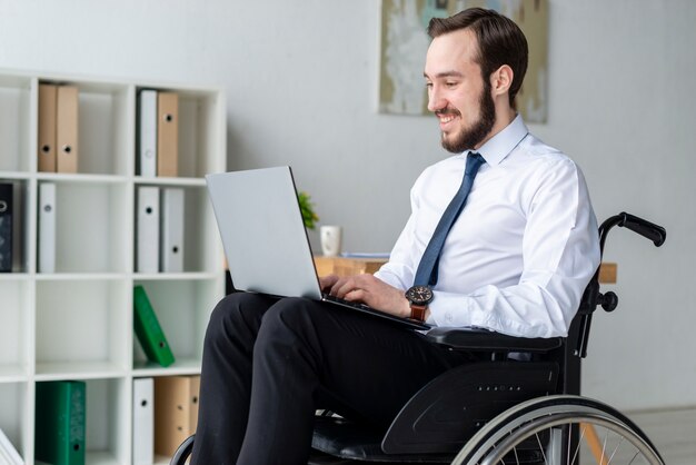 Porträt des Geschäftsmannes, der an einem Laptop arbeitet