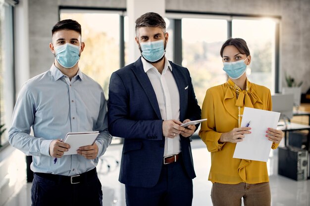 Porträt des Geschäftsteams mit schützenden Gesichtsmasken im Büro