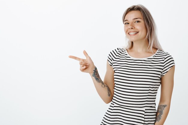 Porträt des glücklichen blonden Mädchens, das im Studio aufwirft