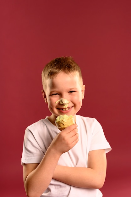 Porträt des glücklichen Jungen, der Eis isst