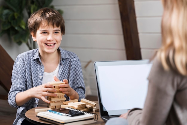 Porträt des glücklichen Jungen, der Jenga spielt