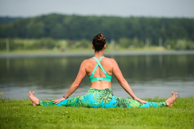 Porträt des Glücks junge Frau, die Yoga im Freien praktiziert