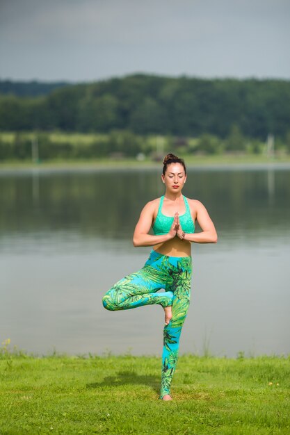 Porträt des Glücks junge Frau, die Yoga im Freien praktiziert