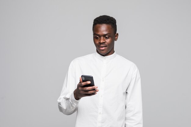 Porträt des gutaussehenden Afro-Mannes, der Nachrichten an seinen Geliebten sendet und erhält, lokalisiert auf grauem Hintergrund