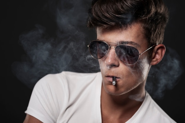 Porträt des gutaussehenden Mannes mit Zigarette