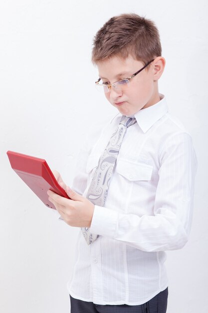 Porträt des jugendlich Jungen mit Taschenrechner über weißem Hintergrund