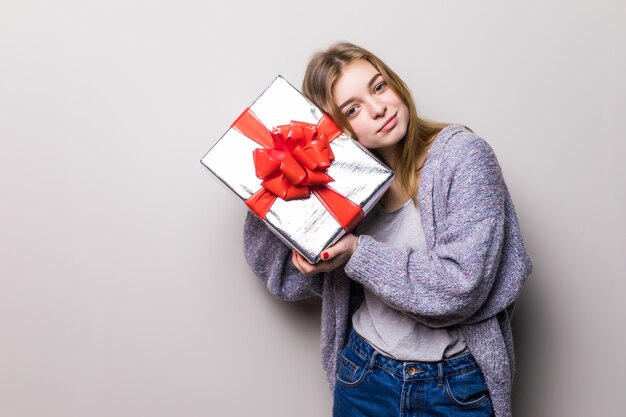 Porträt des jugendlich Mädchens, das Geschenk hält und innerhalb der Box isoliert hört