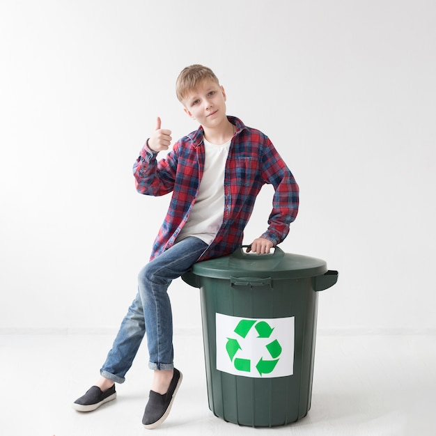 Porträt des Jungen, der glücklich ist, zu recyceln