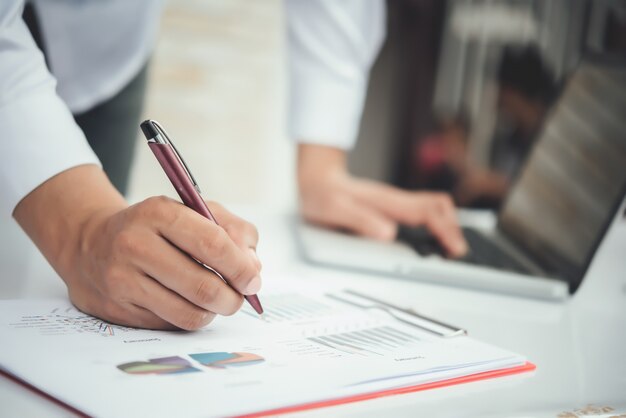 Porträt des jungen Geschäftsmannes, der an seinem Schreibtisch im Büro sitzt