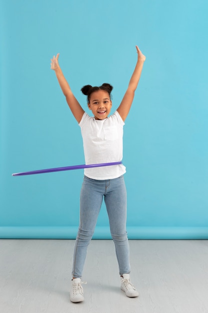 Kostenloses Foto porträt des jungen glücklichen mädchens mit hula-hoop