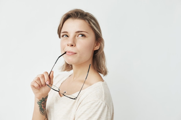 Porträt des jungen hübschen Mädchens lächelnd denken träumende beißende Brille.