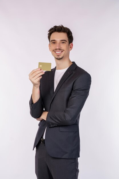 Porträt des jungen lächelnden gutaussehenden Geschäftsmannes, der die Kreditkarte lokalisiert über weißem Hintergrund zeigt