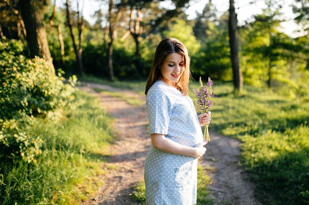 Porträt des jungen Mädchens auf Gras- und Baumparklandschaft