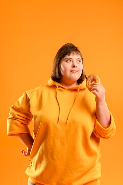 Porträt des jungen Mädchens, das einen Donut hält