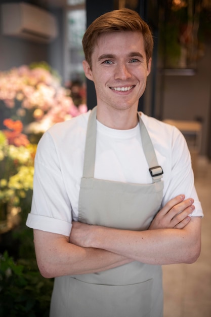 Kostenloses Foto porträt des jungen männlichen floristen bei der arbeit