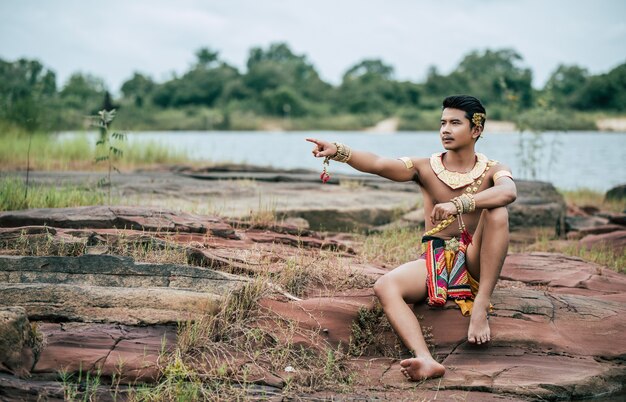 Porträt des jungen Mannes in traditioneller Tracht posiert in der Natur in Thailand