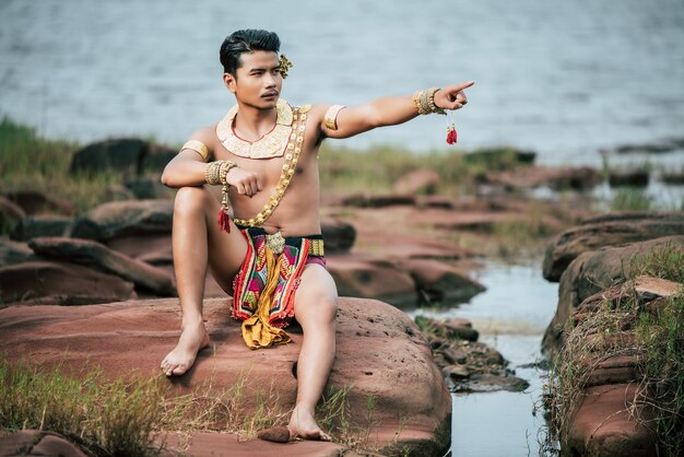 Porträt des jungen Mannes in traditioneller Tracht posiert in der Natur in Thailand