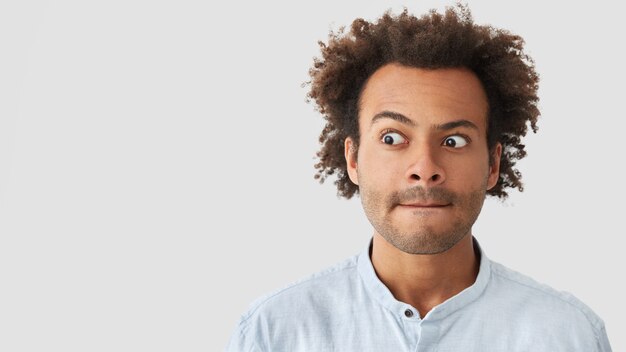 Porträt des jungen Mannes mit dem lockigen Haar, das Hemd trägt