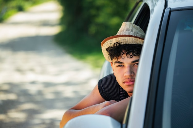 Porträt des jungen Mannes schauend vom Autofenster