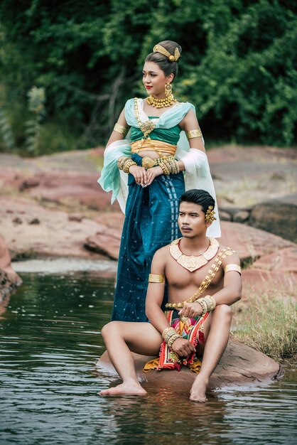 Porträt des jungen Mannes und der Frau, die schöne traditionelle Kostümhaltung in der Natur in Thailand tragen