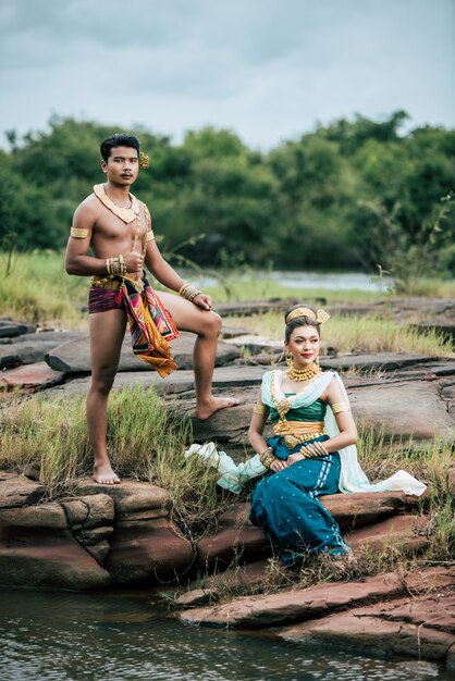 Porträt des jungen Mannes und der Frau, die schöne traditionelle Kostümhaltung in der Natur in Thailand tragen