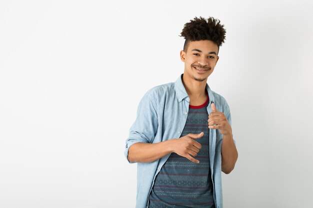 Porträt des jungen schwarzen Hipster-Mannes, der auf lokalisiertem weißem Studiowandhintergrund, stilvolles Outfit, lustige Afro-Frisur, lächelnd, glücklich, kühlen Kerl aufwirft