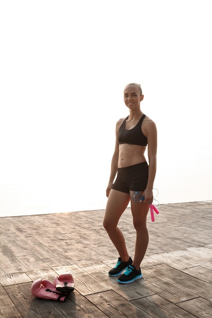 Kostenloses Foto porträt des jungen sportlichen schönen mädchens, das sich auf das boxtraining am meer vorbereitet.