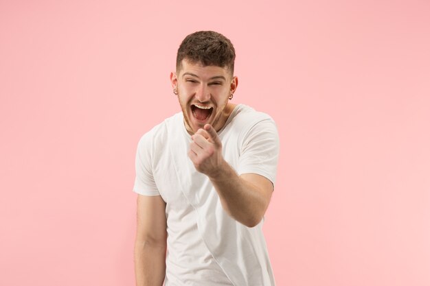 Porträt des jungen trendigen Mannes auf rosa Hintergrund. Emotionaler Ausdruck.