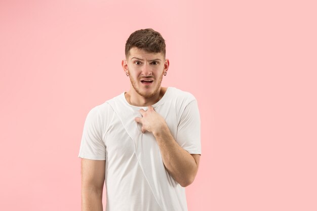 Porträt des jungen trendigen Mannes auf rosa Hintergrund. Emotionaler Ausdruck.