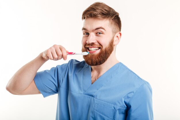 Porträt des jungen Zahnarztes, der Patienten lehrt, wie man Zähne putzt