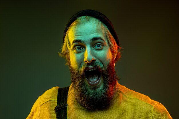 Porträt des kaukasischen Mannes lokalisiert auf Gradientenstudiohintergrund im Neonlicht