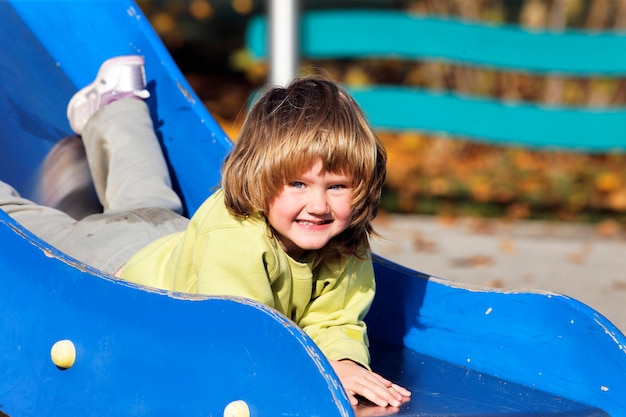 Porträt des Kindes, das auf buntem Spielplatz spielt