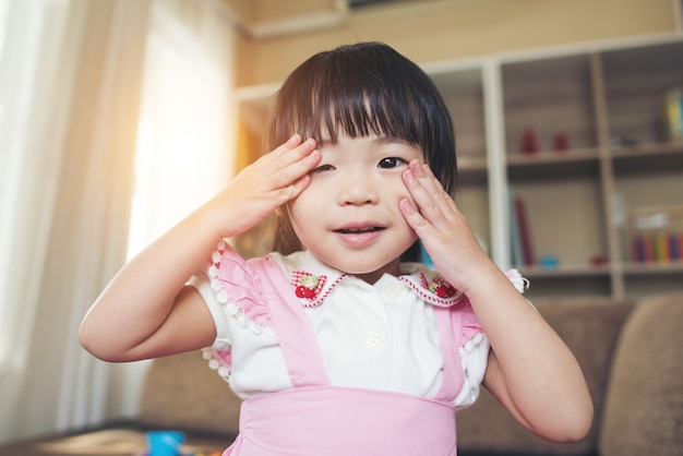Porträt des kleinen asiatischen Mädchens, das in ihrem Haus spielt