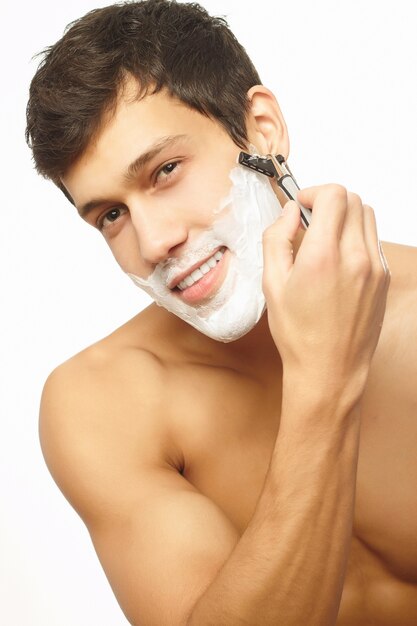 Porträt des lächelnden gutaussehenden Mannes, der sich rasiert