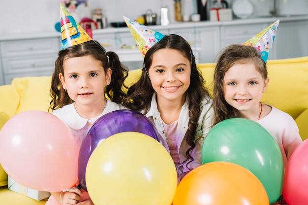 Kostenloses Foto porträt des lächelnden netten mädchens mit bunten ballonen