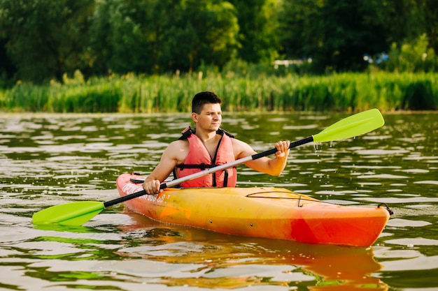 Porträt des männlichen kayaker kayak fahrend auf see Kostenlose Fotos