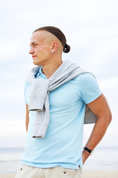 Porträt des Mannes am Strand im blauen T-Shirt