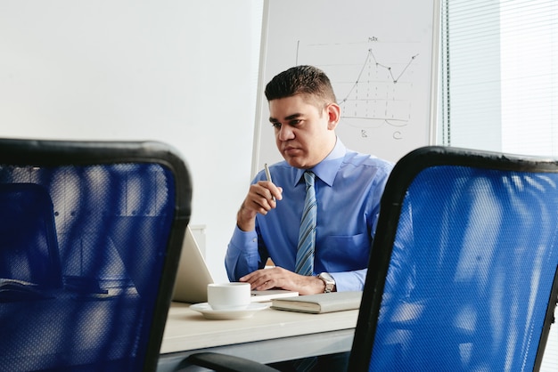 Porträt des Mannes arbeitend im Büro am Laptop