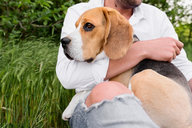 Porträt des Mannes, der niedlichen kleinen Hund hält