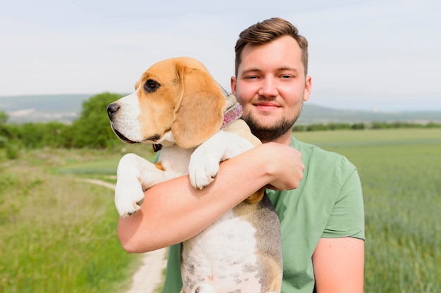 Porträt des Mannes, der seinen entzückenden Hund hält