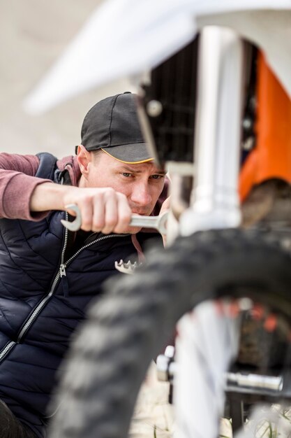 Porträt des Mannes, der versucht, Motorrad zu reparieren