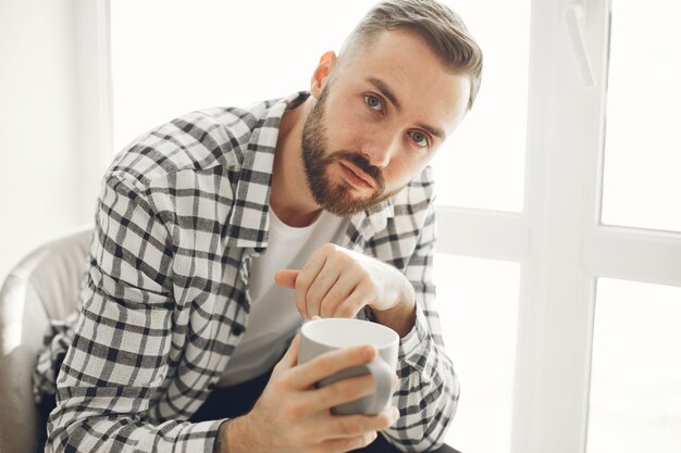 Porträt des Mannes, der zu Hause mit Tasse Kaffee entspannt