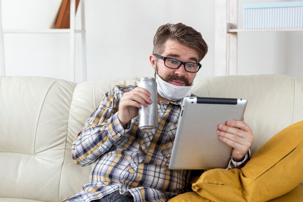 Porträt des Mannes mit Gesichtsmaske, die Tablette hält